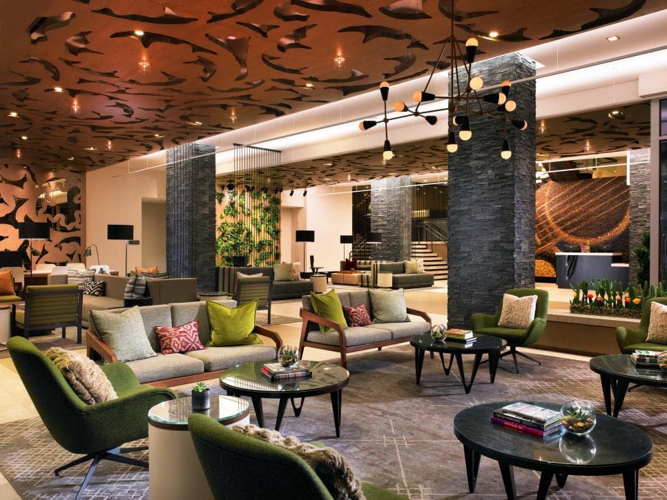 Elegant hotel lobby interior with contemporary furniture and artistic ceiling accents.