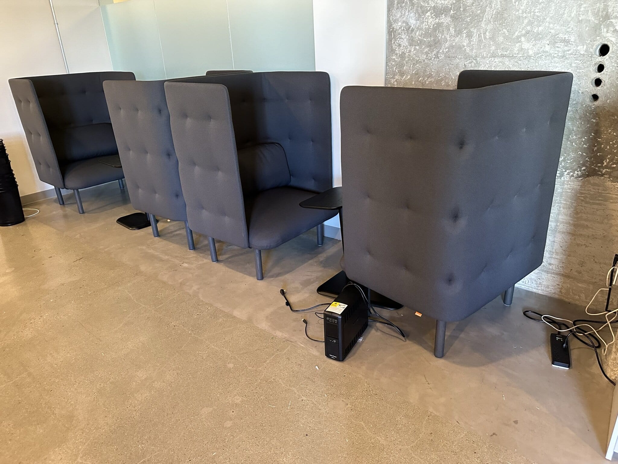 Set of four black modern office lounge chairs with high backs and tufted upholstery.