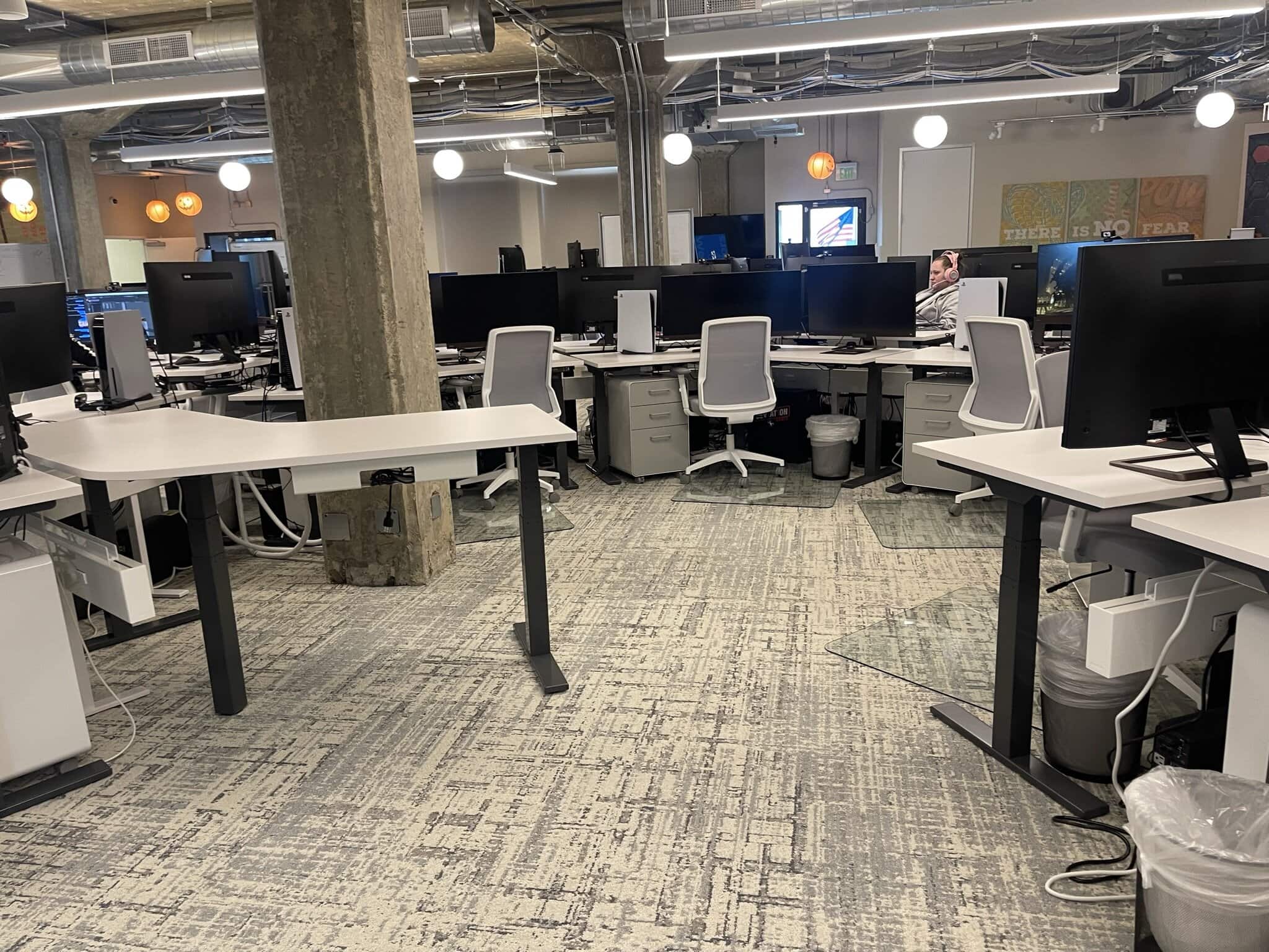 Modern office furniture setup with desks and chairs in a corporate environment.