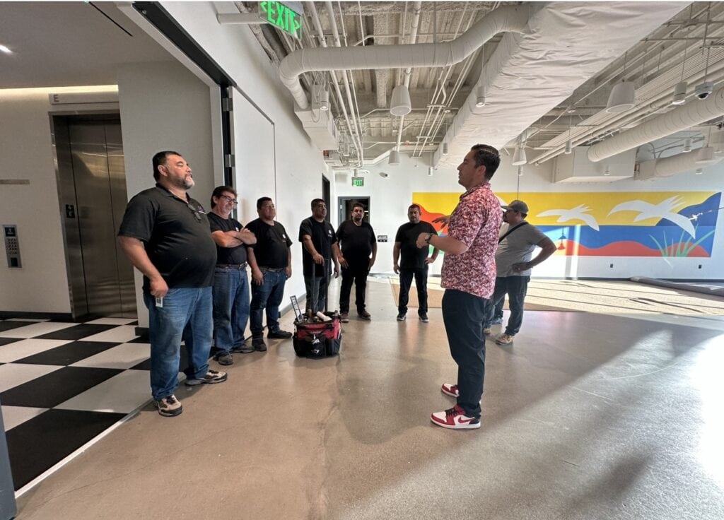 Group of people receiving installation training in a modern indoor space.