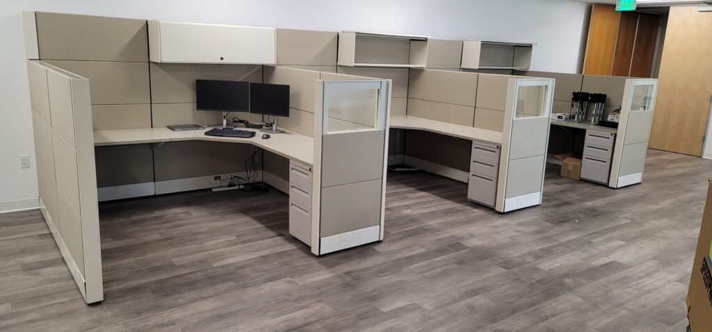 Modern pre-owned office cubicles with privacy panels and workspace desks.