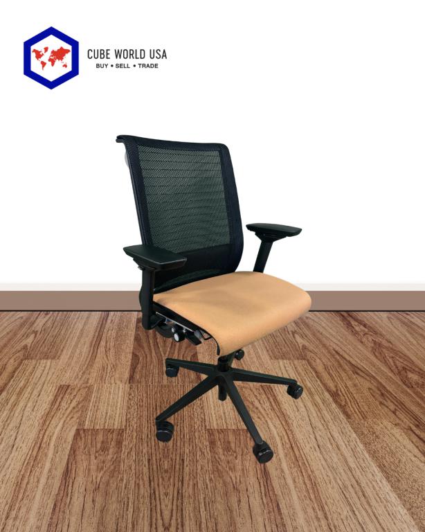 Office ergonomic chair with black mesh back and beige cushioned seat, on wooden floor.