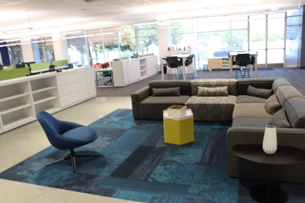 Contemporary office lounge with pre-owned cubicles and stylish furniture setup.