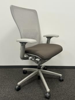 Ergonomic office chair with mesh back, adjustable armrests, and cushioned seat for comfort.
