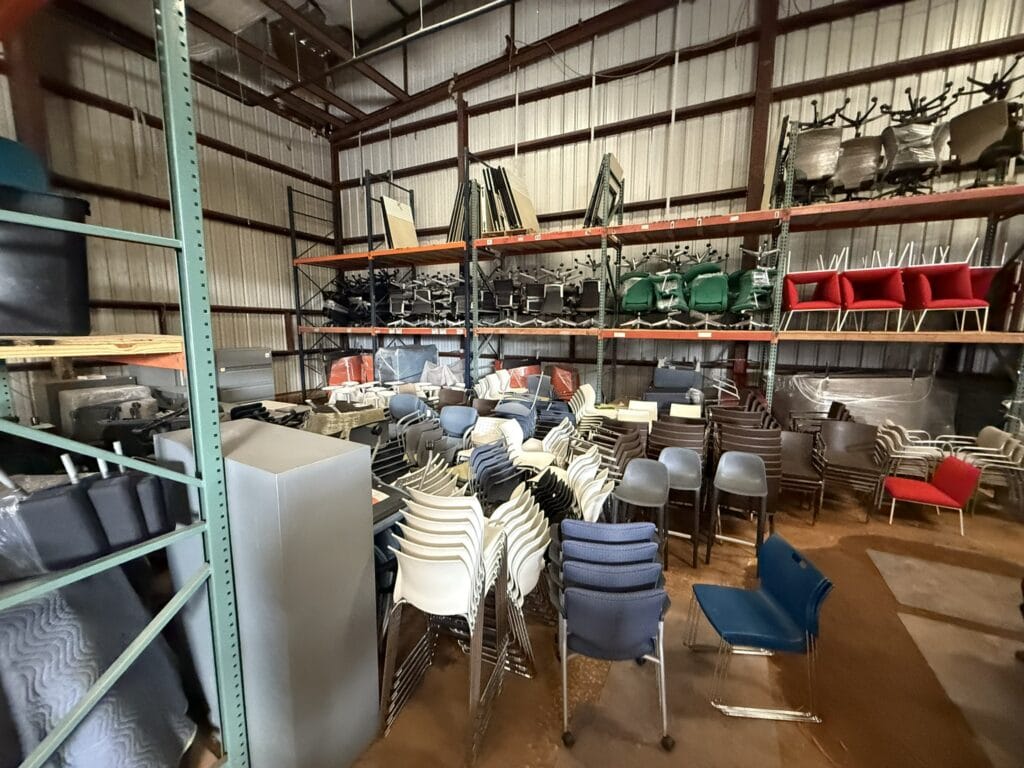 Warehouse with stacked chairs and office furniture for rent.