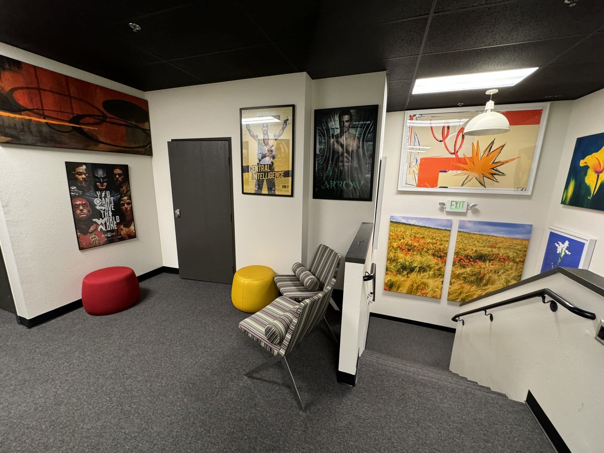 Contemporary office waiting area with colorful artwork and seating.