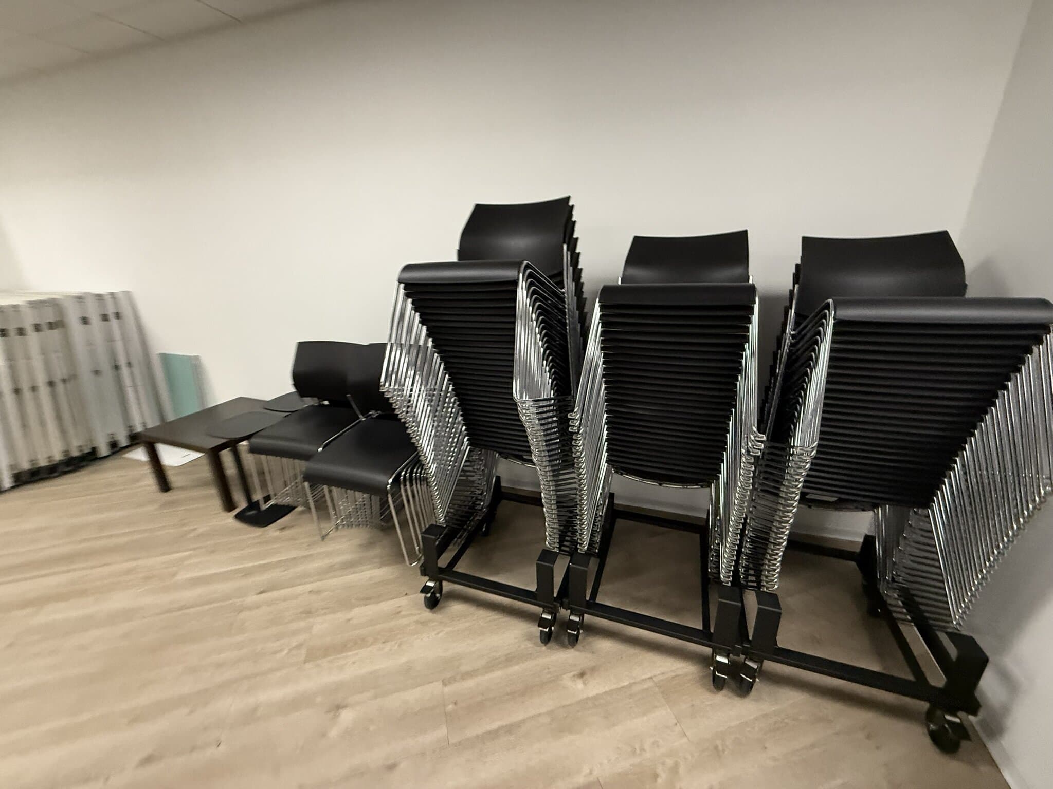 Office chairs stacked on a rolling cart for easy storage and transport.