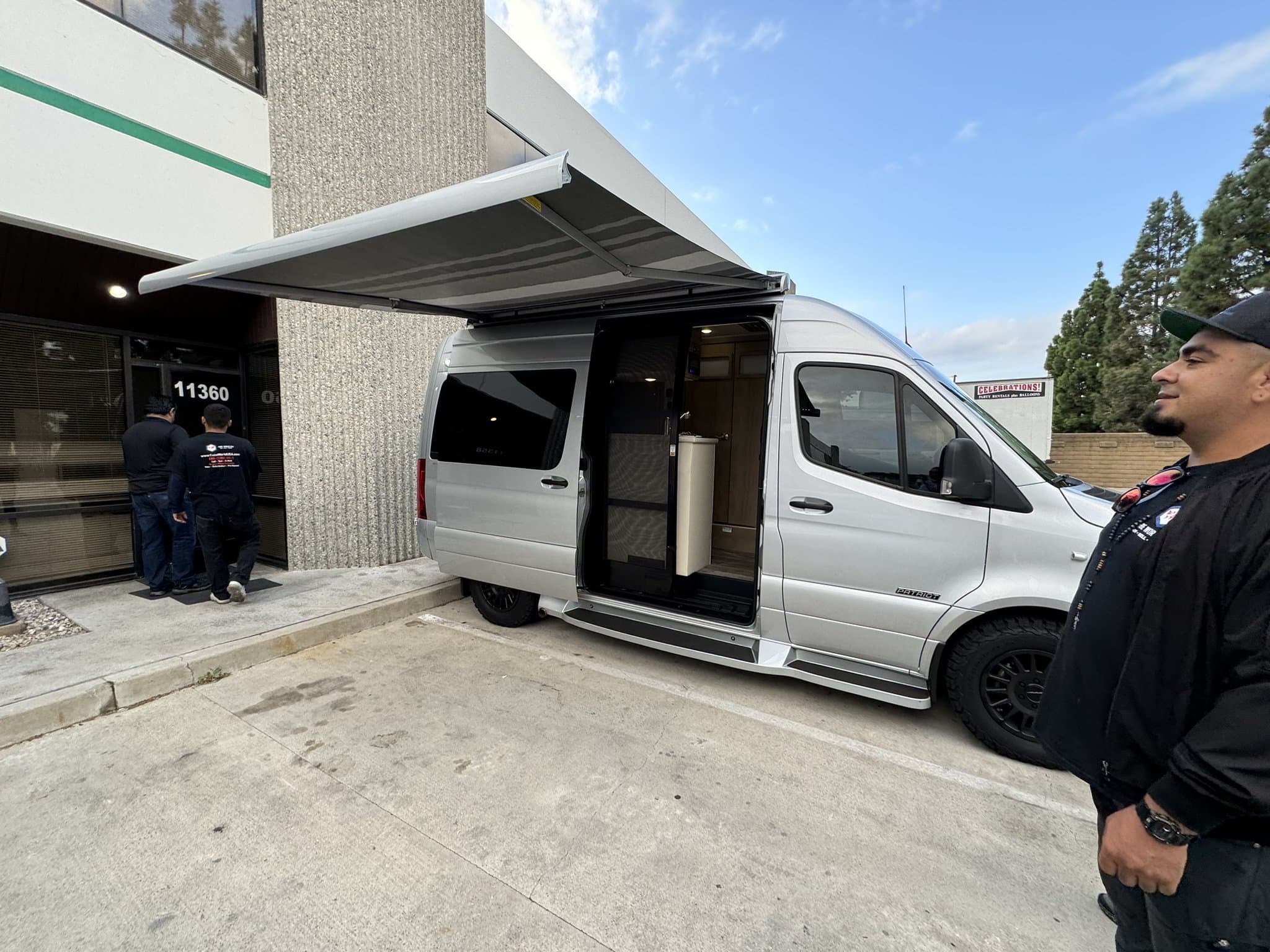 Mobile installation van with awning for outdoor setup at Cube World USA.