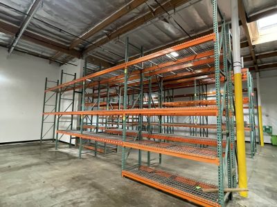 Storage racks for office furniture in a warehouse setting.