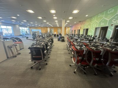 Office furniture liquidation with rows of desks and chairs in a spacious, well-lit room.