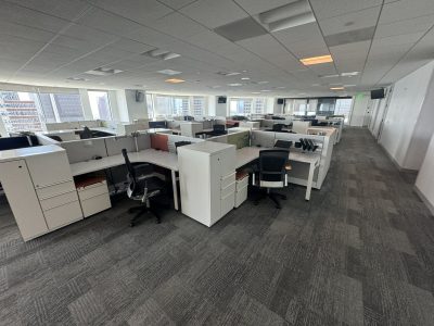 Office furniture liquidation with modern desks and workstations in a spacious, well-lit office envir.