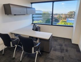 Office furniture liquidation with modern desks and chairs in a bright, spacious workspace.